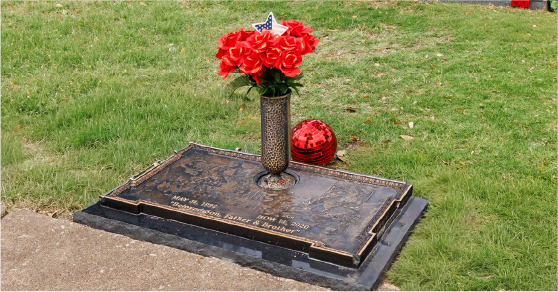 Flush bronze cemetery memorial with flowers in North Texas